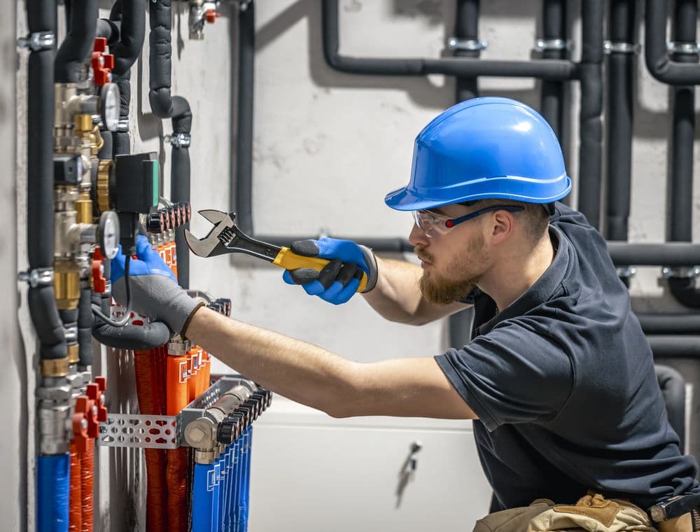 A technician working on boiler-room pipework